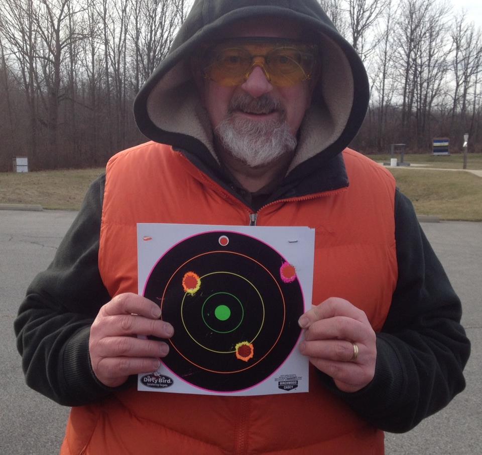 Me, shivering, with the target I used for shooting 12 gauge shotgun slugs at 50 yards. Those are really big holes. Three out of five on the target--I'm happy with that.